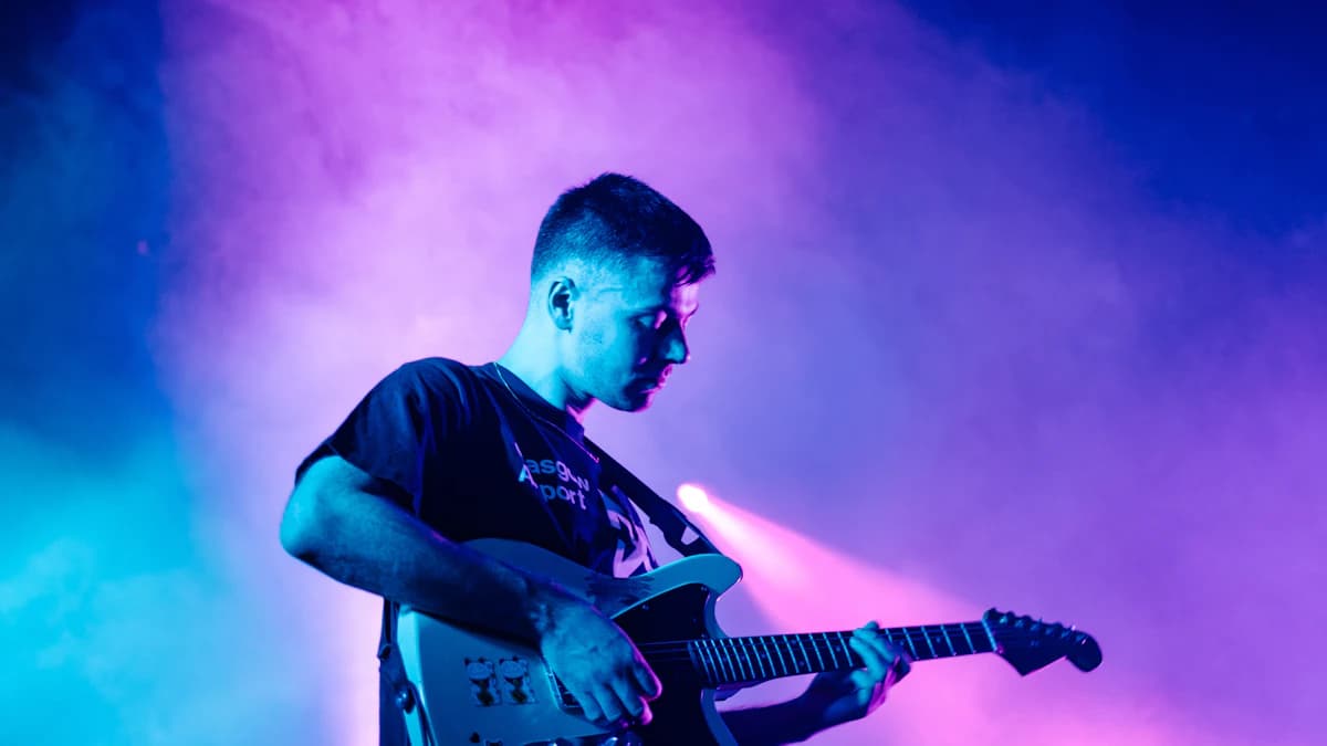 Guitarist performing under stage lights